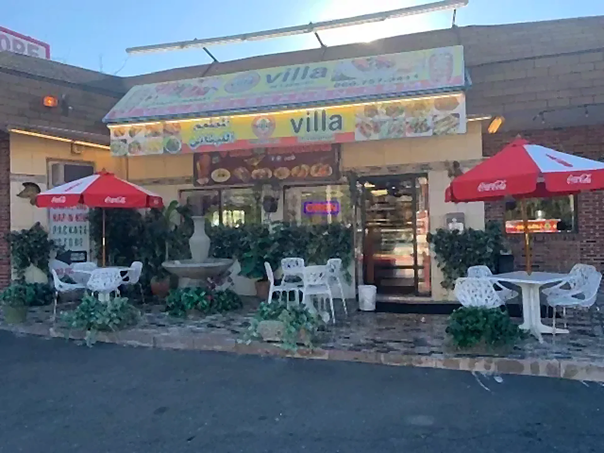 Restaurant storefront with red umbrellas and patio tables