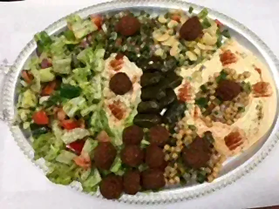 Large sharing tray with salads, dips, falafel and grape leaves